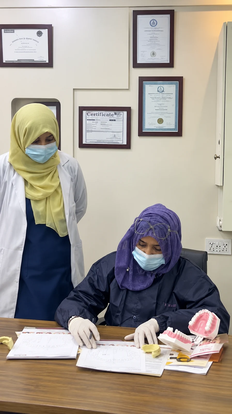 Two Smile team members reviewing paperwork with a dental model